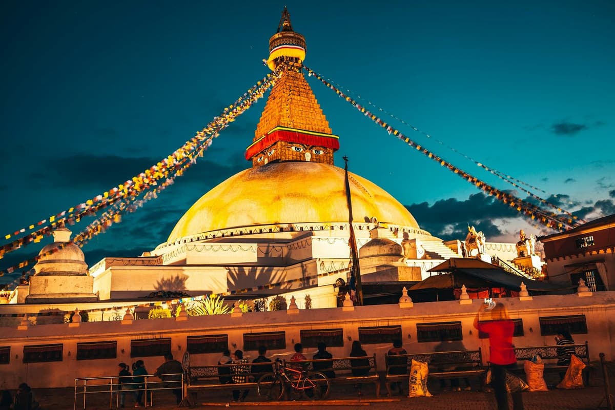 Boudhanath Stupa lit at dusk with prayer flags, the first stop before the evening Pashupatinath aarti.