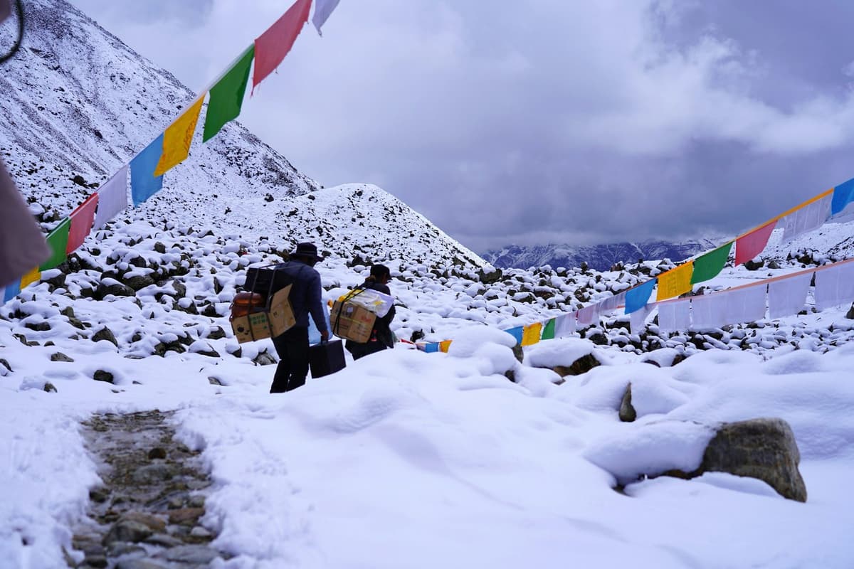 A high camp under prayer flags in fresh snow before the Larke pass on the Manaslu Circuit trek from Kathmandu