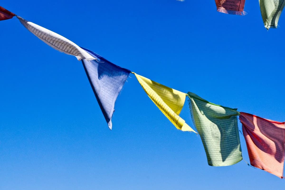 Prayer flags flying against a blue sky in the hills around Kathmandu, as seen on the Tarebhir hike.