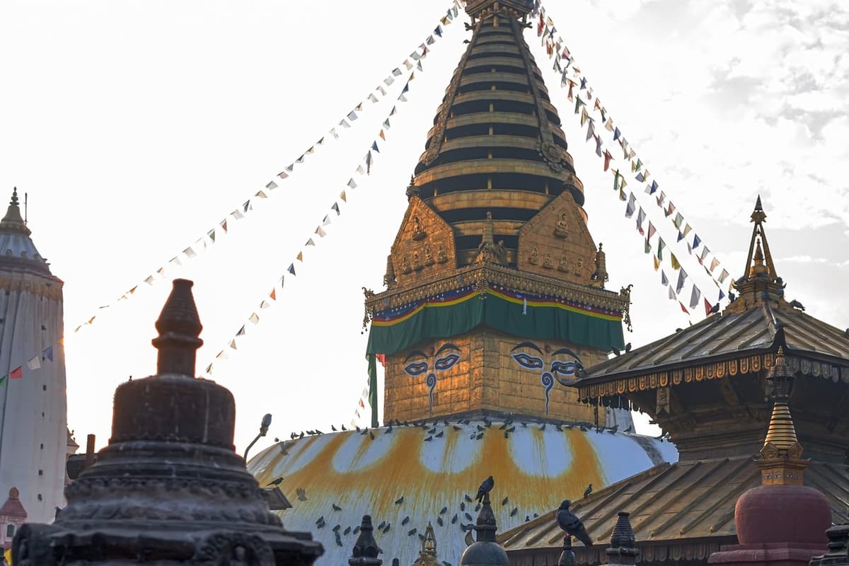 Swayambhunath's golden spire and the Harati temple among prayer flags on the hilltop, the final stop of the Kathmandu walking tour.
