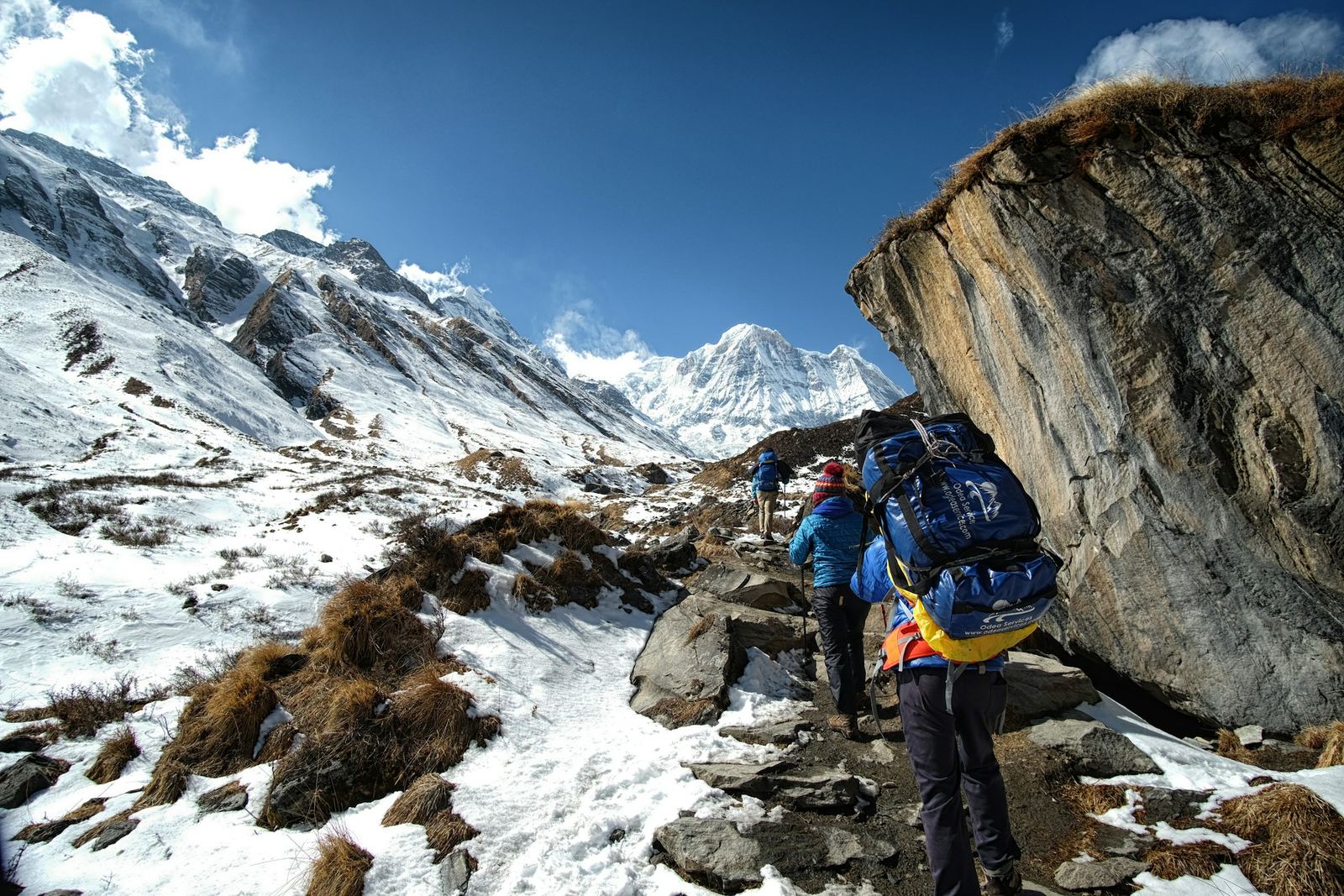 Trekkers climbing a snowy trail into the sanctuary on the Annapurna Base Camp trek