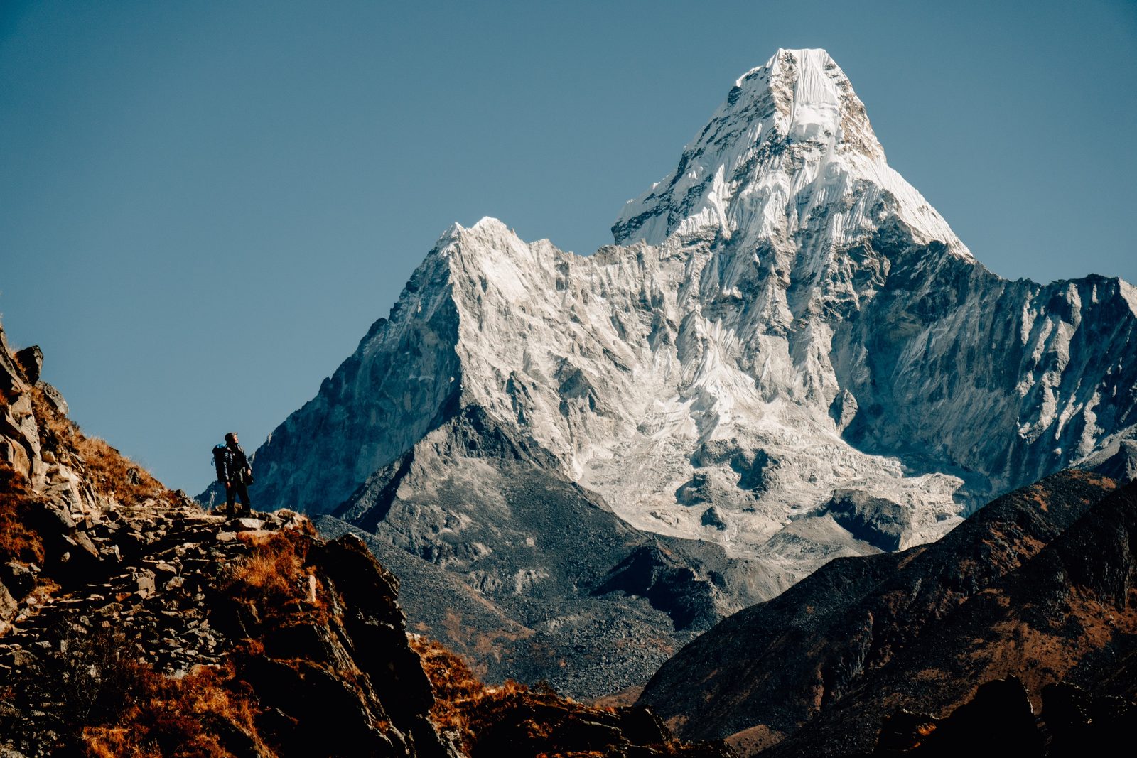 Ama Dablam towering over a hiker on a Khumbu ridge, one of the peaks seen from the Hotel Everest View on the Everest helicopter tour.