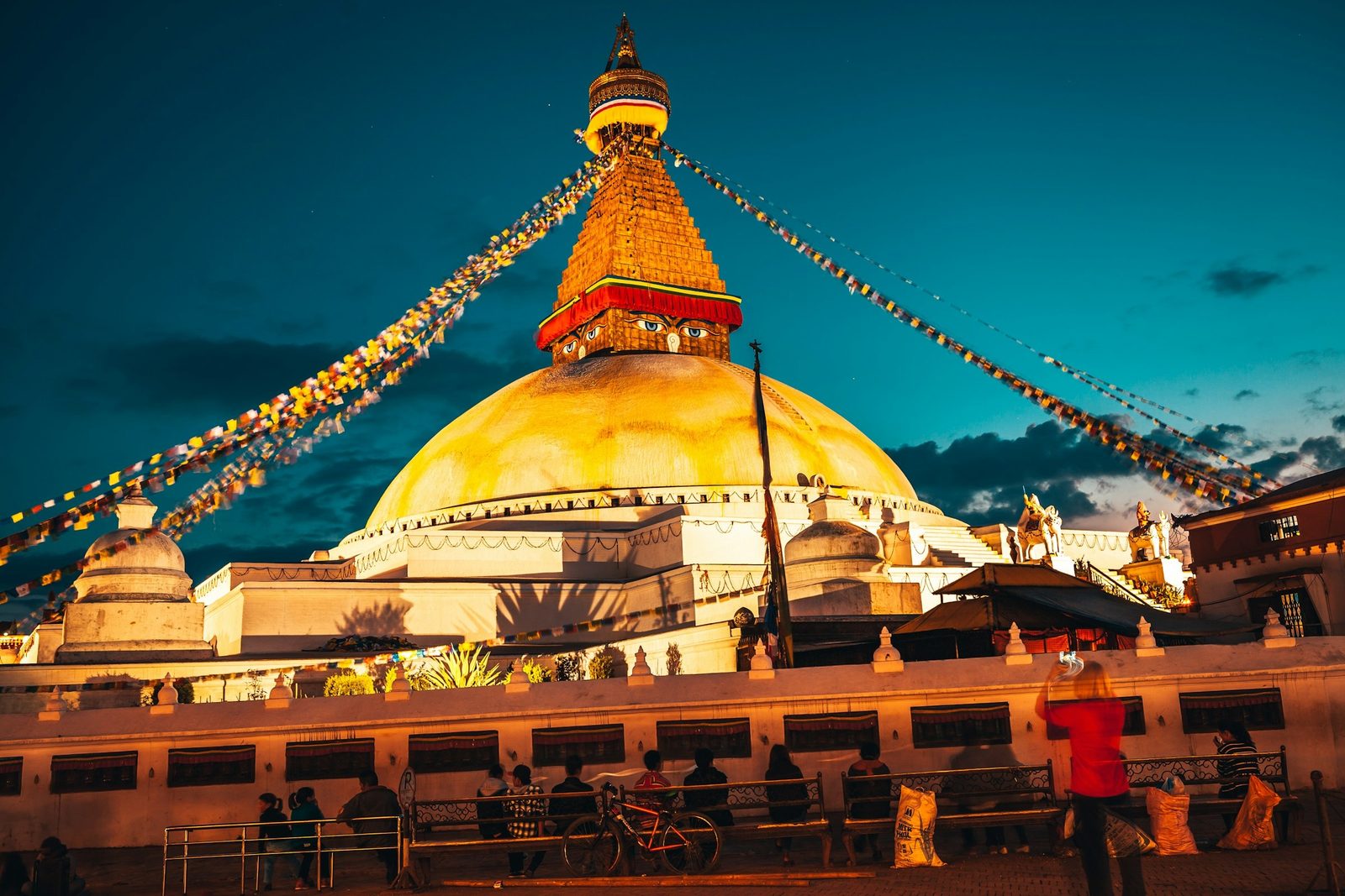 Boudhanath Stupa lit at dusk with prayer flags, the first stop before the evening Pashupatinath aarti.
