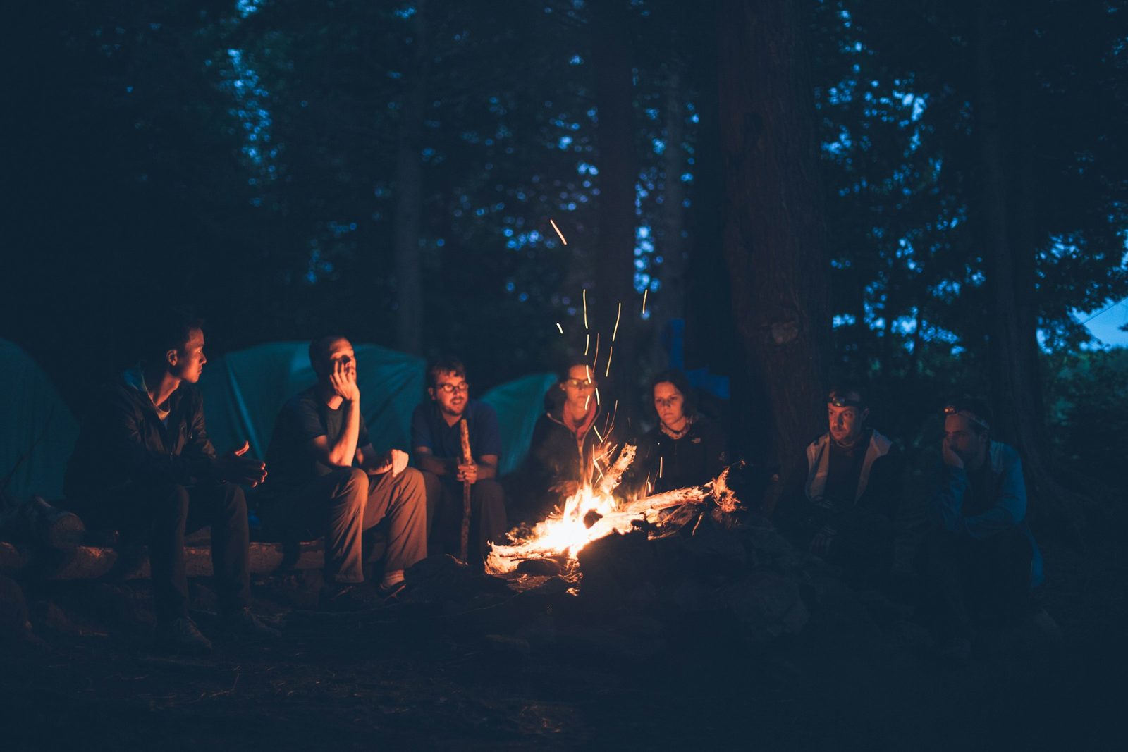 The group around a campfire beside the tents in the evening on the Sukute Beach rafting trip