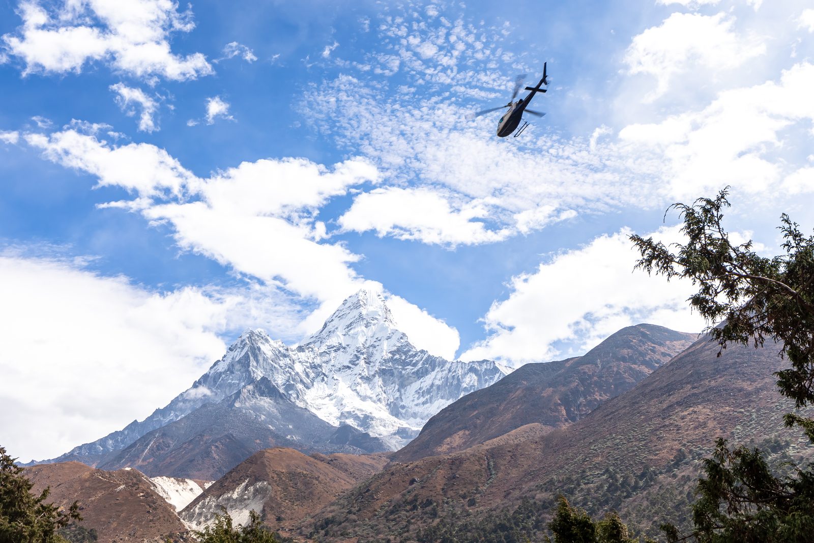 A helicopter over Ama Dablam and the Khumbu valley, a classic sight on the Everest helicopter tour in Nepal.