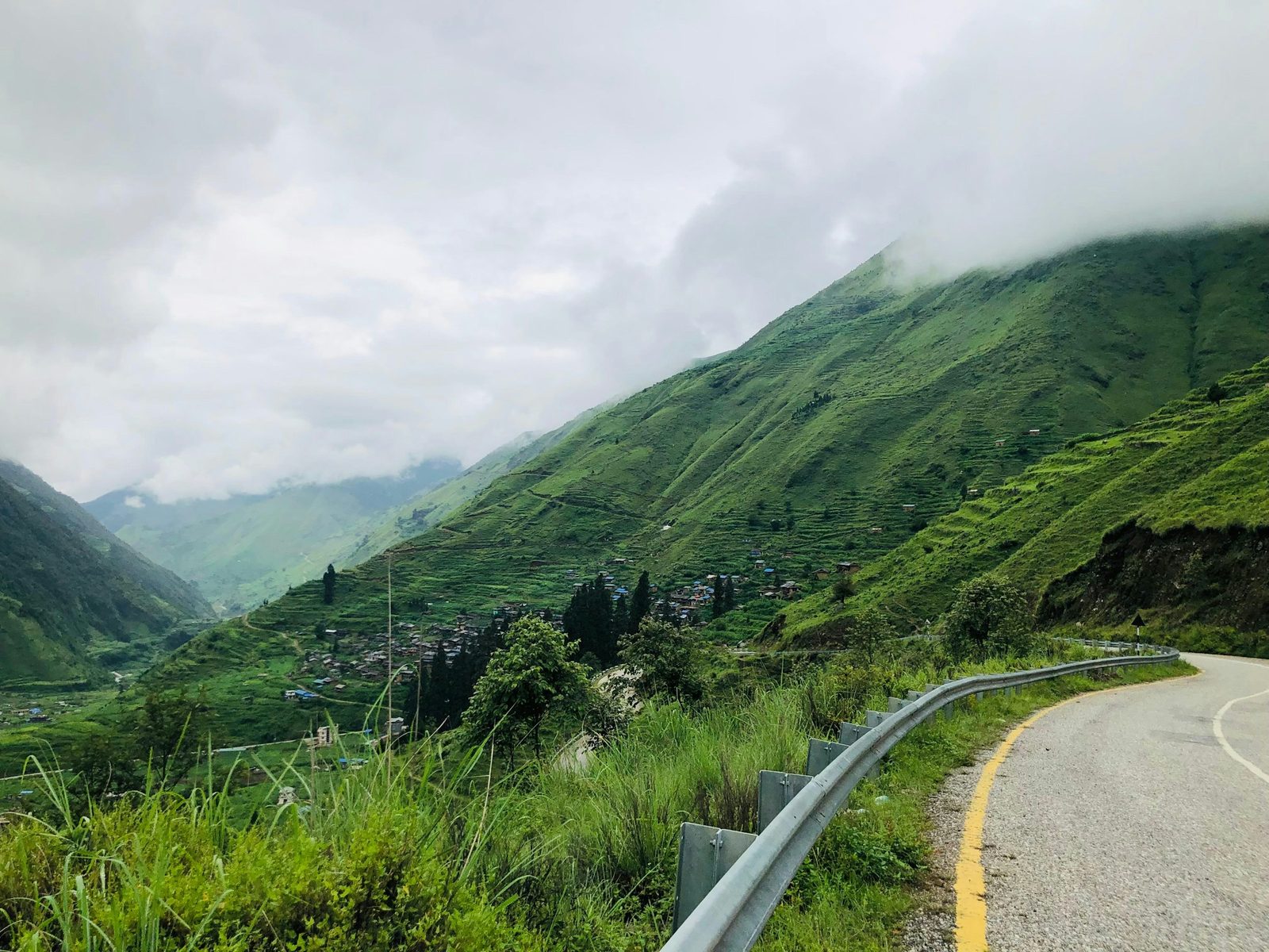 A road winding through misty terraced hills on the drive of the Kulekhani and Daman tour