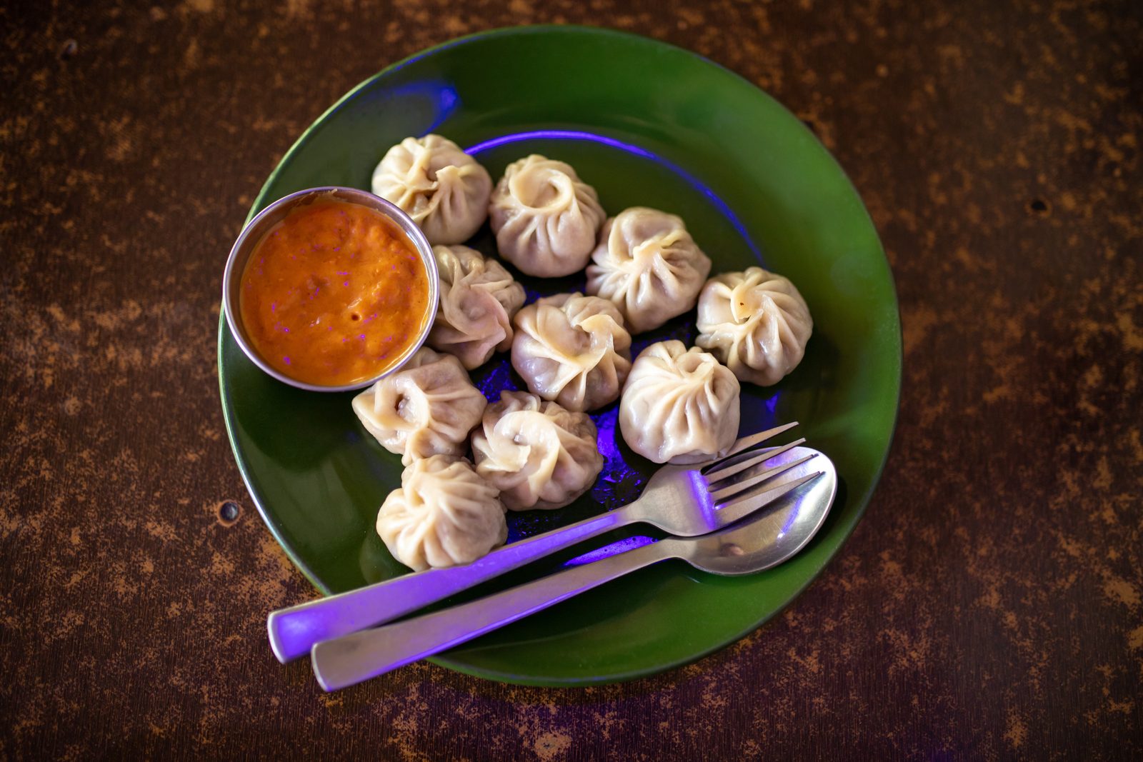 A plate of steamed momo with dipping sauce, the reward at the end of the momo making class.
