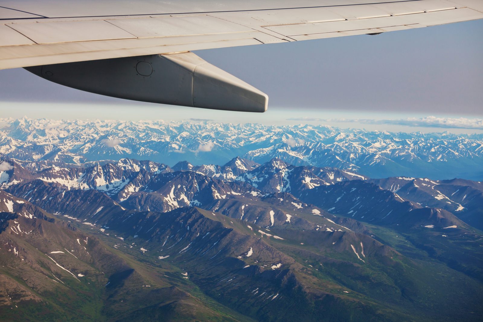 A wide range of snow-capped mountains beneath the aircraft wing, the panorama on the Everest mountain flight.