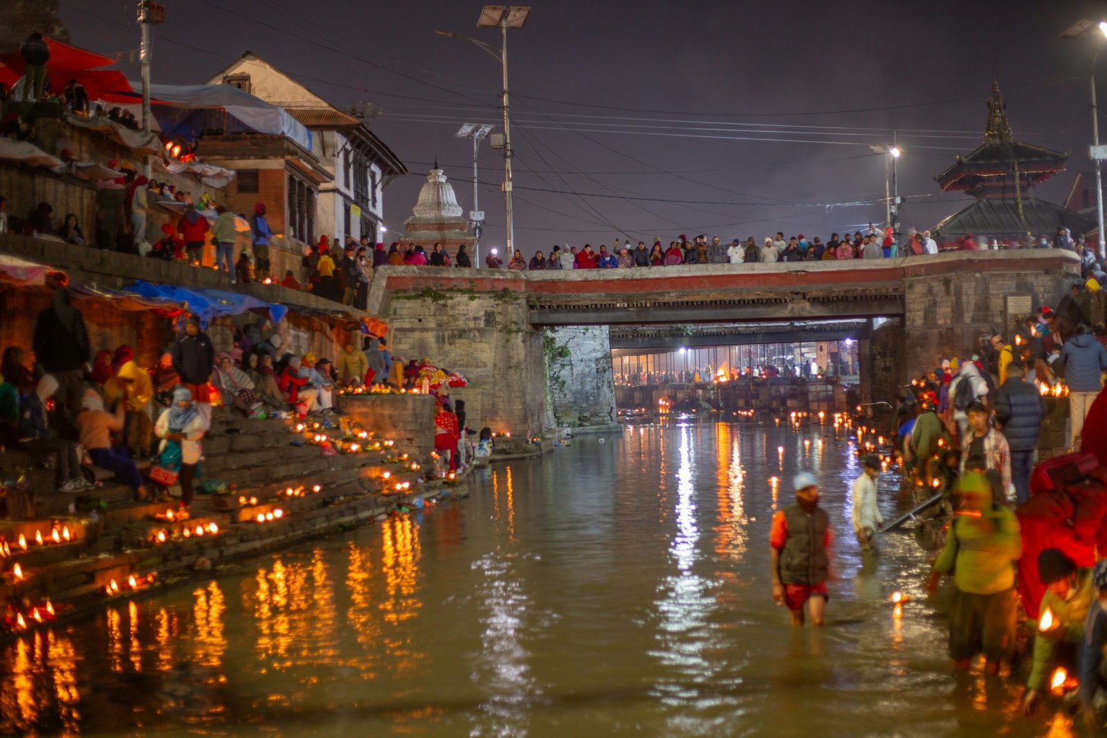 The ghats of the Bagmati lit by lamps at night during the Pashupatinath aarti in Kathmandu.