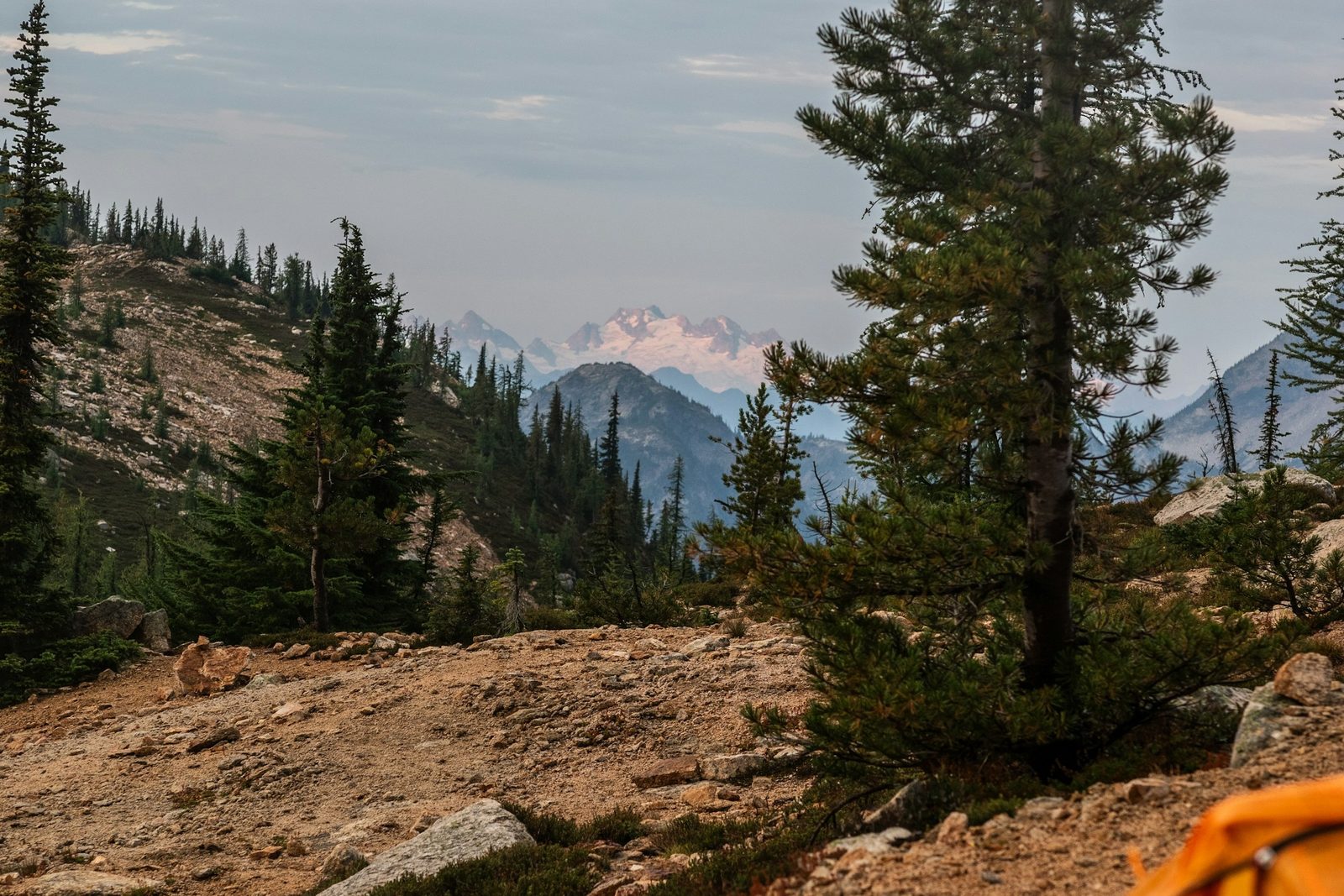 A camp among pine trees with a snow peak beyond, the forest setting of Kakani camping