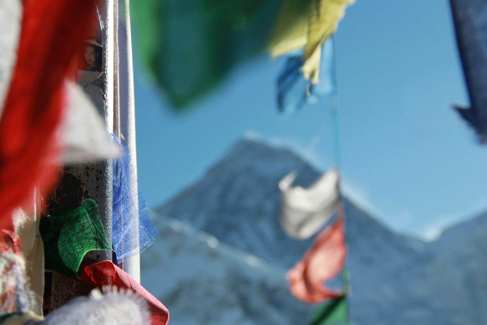 Colourful prayer flags strung in front of a snow peak on the Kalinchowk with Palanchowk Bhagwati tour