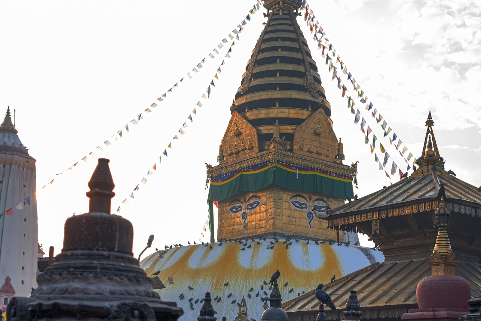 Swayambhunath's golden spire and the Harati temple among prayer flags on the hilltop, the final stop of the Kathmandu walking tour.